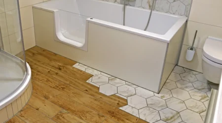 Modernes barrierefreies Badezimmer mit einer Kombination aus Holzboden und sechseckigen Fliesen mit einer barrierefreie Badewanne mit Tür.