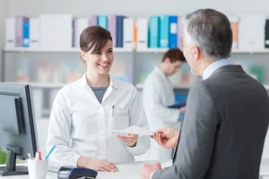 Gesundheitskaufmann übergibt einer jungen Frau ein Formular.