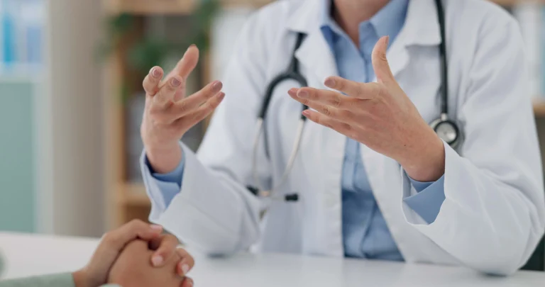 Krankenhaus Gespräch mit Patient. Hände des Arztes bewegen sich vor seinem Oberkörper während der medizinischen Beratung.