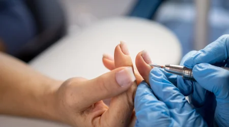 Frau passt einer Klientin die Nagelprothese fachgerecht an.