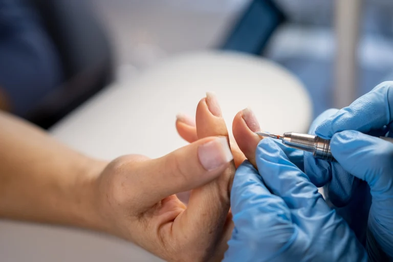 Frau passt einer Klientin die Nagelprothese fachgerecht an.