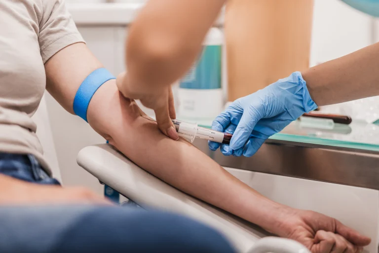 Ein Arzt nimmt seinem Patienten Blut für die Eigenblutbehandlung ab.
